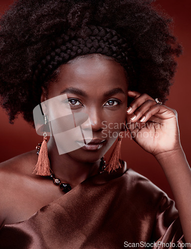 Image of Portrait, natural beauty and black woman with fashion in studio isolated on a red background. Face, makeup cosmetics and confident African model with stylish outfit, traditional jewelry and culture.