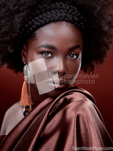 Image of Face, natural beauty and black woman with fashion in studio isolated on a red background. Portrait, makeup cosmetics and serious African model with stylish outfit, traditional jewelry and aesthetic