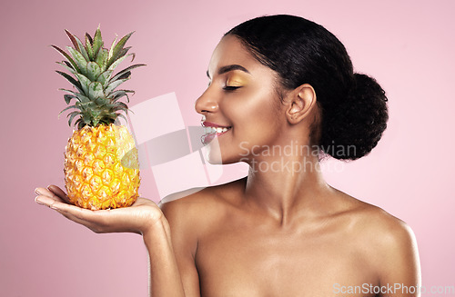 Image of Woman, pineapple and smile for beauty in studio, pink background and healthy vitamin c cosmetics. Happy african model, tropical fruits and nutrition for natural skincare, organic benefits and detox