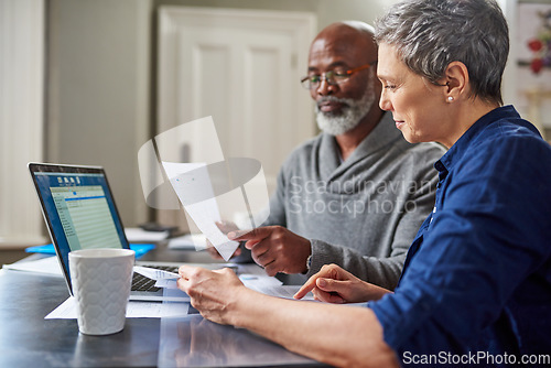 Image of Laptop, documents and finance with a senior couple busy on a budget review in the home together. Accounting, taxes or investment planning with a mature man and woman looking at insurance or savings