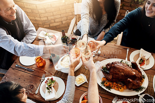 Image of Food, wine toast and people together for celebration, holiday or dinner party with healthy meal. Above group of friends or family hands cheers to celebrate with drinks, lunch and chicken or turkey