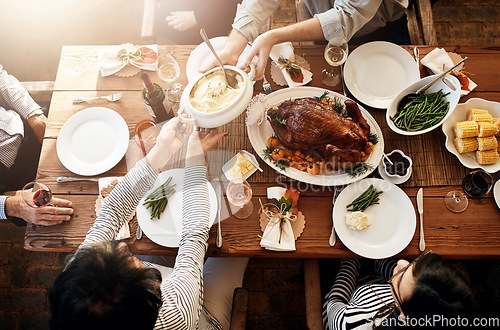 Image of Food, people and eating together at table for holiday celebration or dinner party. Above group of family or friends hands sharing healthy lunch with chicken or turkey, vegetables and wine drinks