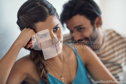 Image of Conflict, upset or sad with a couple arguing on a sofa in their home living room about an affair or breakup. Depression, unhappy or domestic violence with a woman thinking about divorce after a fight