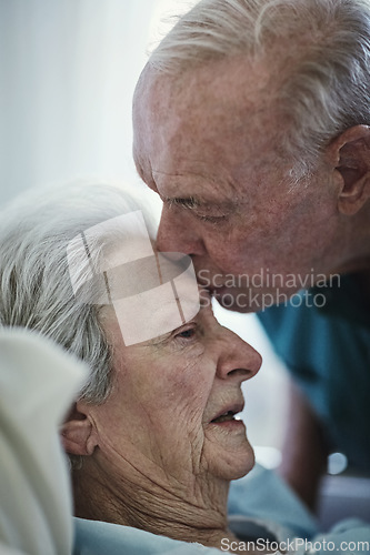 Image of Senior, kiss and couple in hospital for love, visiting sick cancer patient and hope for recovery. Clinic, elderly man and woman kissing on forehead for empathy, kindness and support for healthcare.