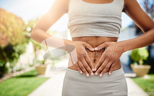 Image of Hands of woman on stomach in park, gut health and fitness for lipo wellness for body target for balance. Gym, healthcare and tummy tuck, model with heart hand sign on belly for muscle exercise goals.