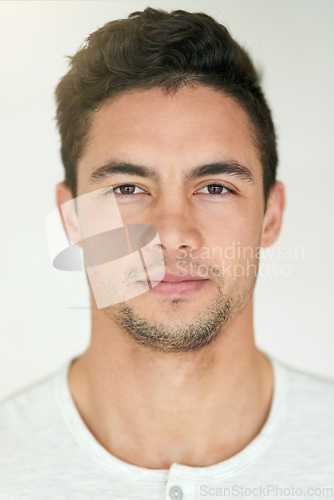 Image of Portrait, face and headshot of man in studio, isolated white background and posing with casual attitude. Handsome young guy, serious male person and pose for ID photo, passport picture and confidence
