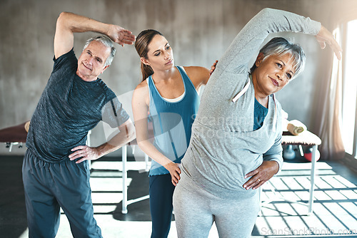 Image of Stretching, helping and senior people with personal trainer in class for fitness, wellness or rehabilitation. Health coach, workout or retirement with elderly patient, man or female in gym warm up