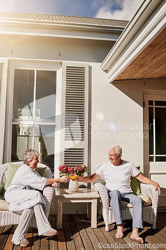 Image of Cheers, patio and senior couple with juice enjoying bonding, quality time and relax in morning. Love, retirement and happy elderly man and woman smile with drink for breakfast outdoors at home