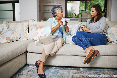 Image of Support, coffee and mother with daughter on sofa in living room for bonding, conversation and free time. Relax, chat and discussion with women talking in family home for generations, reunion or break