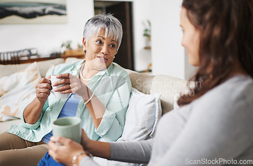 Image of Happy, coffee and mother with daughter on sofa in living room for bonding, conversation and happiness. Smile, chat and discussion with women talking in family home for generations, reunion and break