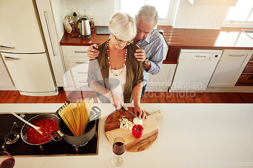 Image of Affection, support or old couple kitchen cooking with love or healthy food for lunch together at home. Hug, embrace or above of senior woman helping an elderly romantic husband in meal preparation