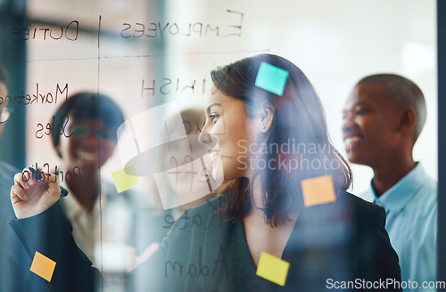 Image of Business people, glass wall and woman writing, strategy in office and brainstorming. Sticky notes, planning and group of employees working on ideas, schedule and collaboration for teamwork at work.