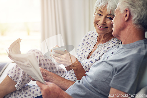 Image of Coffee, newspaper and a senior couple in the bedroom, enjoying retirement in their home in the morning. Tea, reading or love with a happy mature man and woman in bed together to relax while bonding
