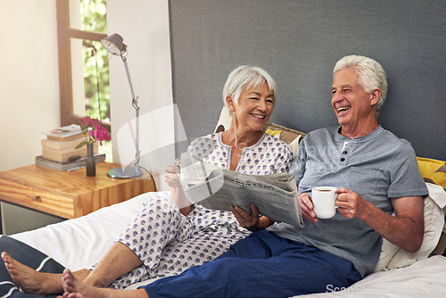 Image of Coffee, newspaper and a mature couple in the bedroom, enjoying retirement in their home in the morning. Tea, reading or love with a happy senior man and woman in bed together to relax while bonding