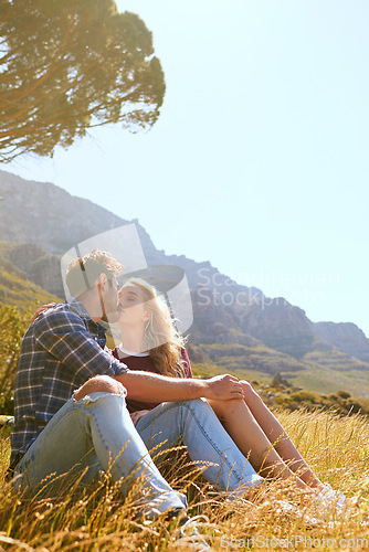 Image of Romance, kiss and love with couple in nature for carefree, bonding or affectionate. Happiness, date and relax with man and woman cuddling in grass field for summer break, happy or relationship mockup