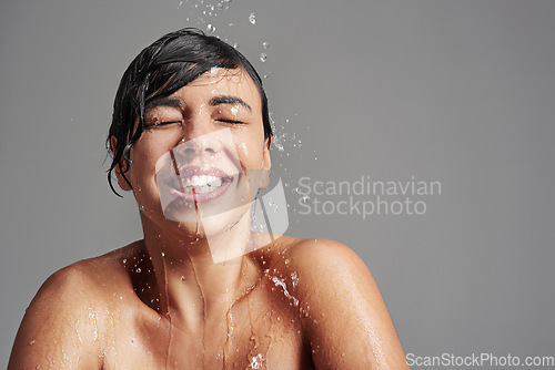 Image of Shower, cleaning and face of woman with water in studio on gray background for wellness, beauty and grooming. Skincare, bathroom and happy female person with splash for washing, hygiene and cleansing