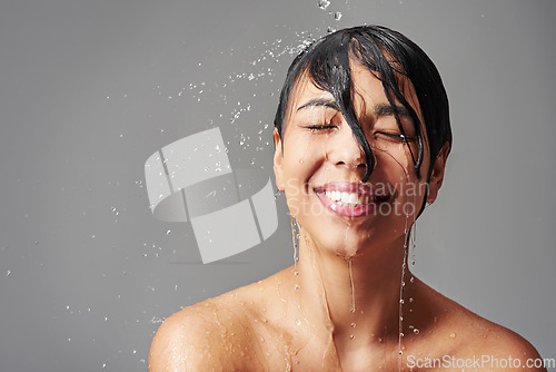 Image of Shower, happy and face of woman with water in studio on gray background for wellness, cleaning and grooming. Skincare, bathroom and female person with beauty for washing hair, body care and hygiene