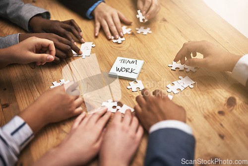 Image of Teamwork, puzzle and hands of business people in collaboration in a meeting together planning strategy at work. Circle, professional and group in a table with synergy as a workforce for innovation