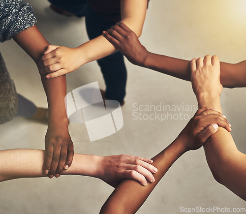 Image of Collaboration, arms in a circle and business people in the office from above for support or community. Teamwork, trust and solidarity with an employee group or team standing together in a huddle