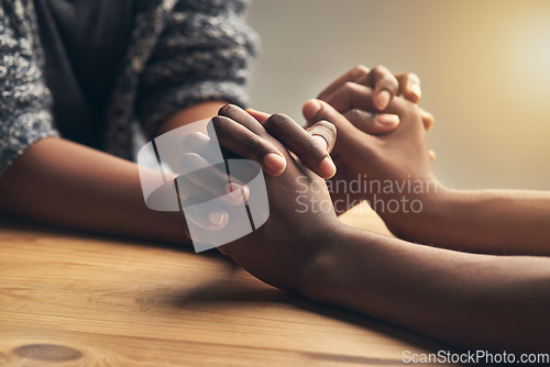 Image of Love, partnership and couple holding hands for support, unity and sympathy by wood table. Empathy, care and couple or friends with affection in an intimate bonding moment together for grief and loss.