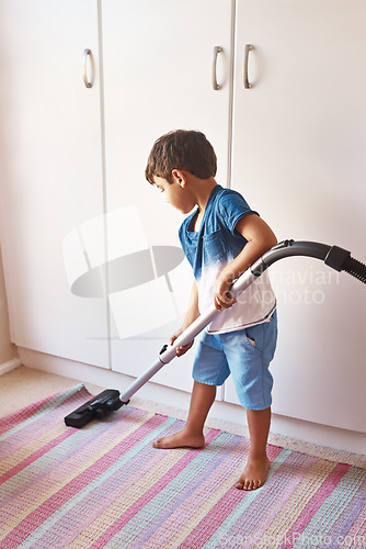 Image of Vaccuming carpet, clean and a child in room for chores, learning and housework with a vacuum. Housework, house and a boy kid cleaning a mat for responsibility, routine and with machine in a bedroom