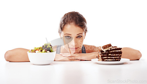 Image of Portrait, food and choice with a woman in studio on a white background to decide between a salad or cake. Diet, nutrition or health with a chocolate dessert and a healthy bowl of fresh vegetables