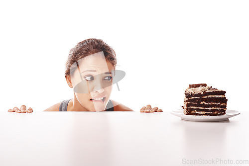 Image of Hungry, temptation and a woman with chocolate cake on a table isolated on a white background in a studio. Unhealthy, sneaky and a young lady looking at a dessert while on a diet or healthy lifestyle