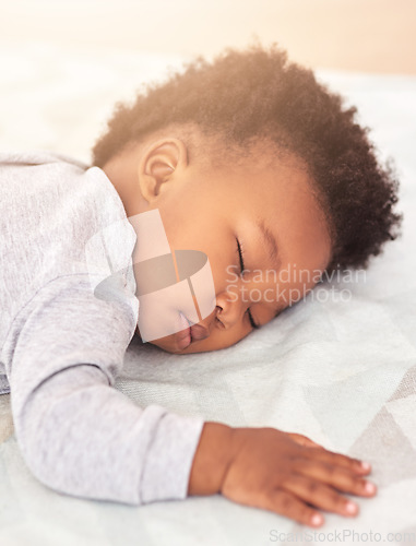 Image of Tired, bed and baby sleeping in home on blanket for rest, nap time and dreaming in nursery. Childcare, newborn and cute, adorable and African child in bedroom sleep for comfort, relaxing and calm