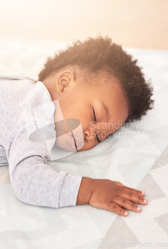 Image of Comfort, bed and baby sleeping in home on blanket for rest, nap time and dreaming in nursery. Childcare, newborn and cute, tired and African child in bedroom sleep for comfortable, relaxing and calm