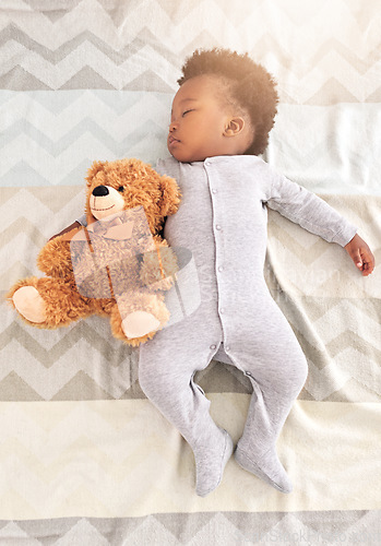 Image of Teddy bear, bed and baby sleeping in home with lens flare for rest, nap time and dreaming in nursery. Childcare, newborn and cute, tired and African child in bedroom sleep for comfort, relax and calm