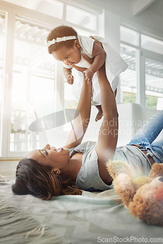 Image of Bonding, black woman and baby playing on floor with love, happiness and happy time together in living room. Smile, mother and daughter in playful embrace, laughing parent and newborn in family home.