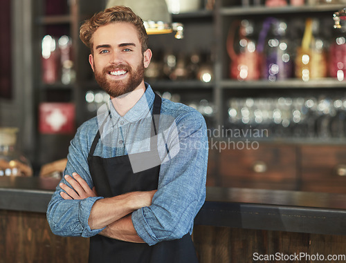 Image of Happy, barista and portrait of man in a coffee shop by the counter in his startup cafeteria. Smile, confidence and small business owner or waiter with crossed arms and success in his new restaurant.