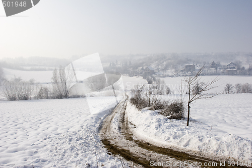 Image of misty winter view of farm track in the snow