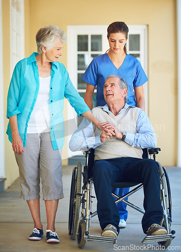 Image of Wife, caregiver or old man talking in wheelchair in hospital clinic helping an elderly patient for support. Disabled, couple or trusted healthcare nurse speaking with senior people with a disability