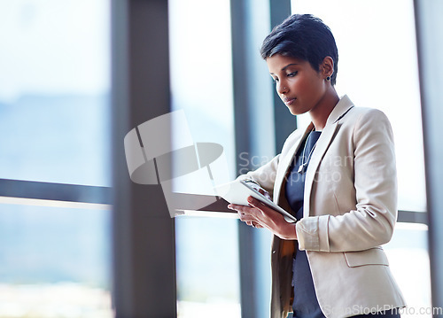 Image of Tablet, mockup and research with a business woman leaning against a glass wall or window at the office. Technology, corporate and space with a young professional female employee working online