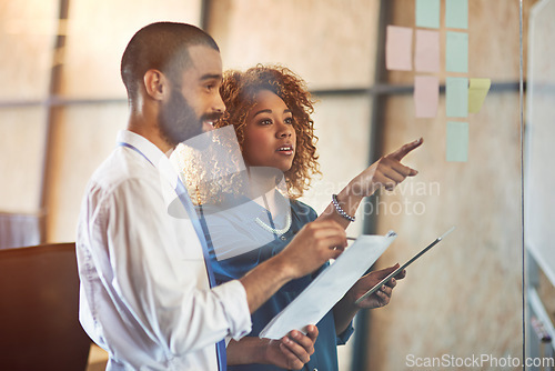 Image of Teamwork, brainstorming or planning on tablet in modern office for strategy conversation and sticky notes. Businesspeople, talking and moodboard or idea, document and corporate company workplace