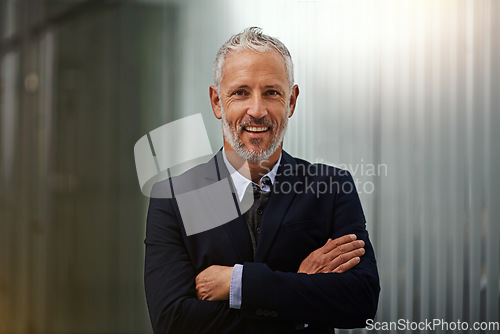 Image of Portrait, mission and arms crossed with a business man in his office, looking happy about his company growth. Vision, mindset and confidence with a senior male corporate manager standing at work