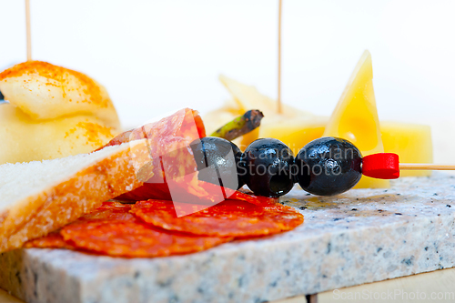 Image of mix cold cut on a stone with fresh pears