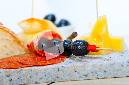 Image of mix cold cut on a stone with fresh pears