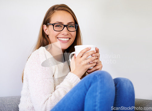 Image of Portrait, coffee and smile of woman in home enjoying caffeine, espresso or cappuccino in living room. Happiness, tea and female person with glasses on sofa, drinking beverage and relax in house alone