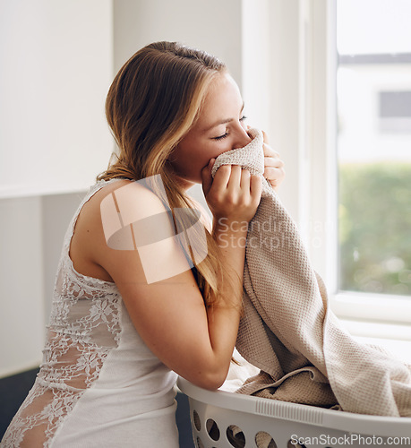 Image of Smelling, woman and laundry with clothes in basket and happy with clean apartment towel. Female person, cleaning or fabric for self care, lifestyle and happiness in a household with fresh clothing.