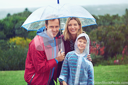 Image of Happy, rain and portrait of a family with umbrella outdoor in nature for fun, happiness and quality time. Man, woman and boy child together with water drops and freedom while playing on vacation