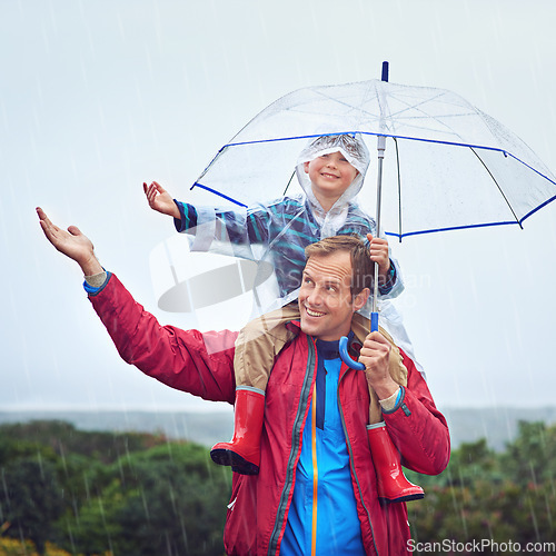 Image of Father, child or family with an umbrella in rain outdoor for fun, happiness and quality time. Happy man and boy kid in nature with hand to catch water drops for learning, freedom and travel or play