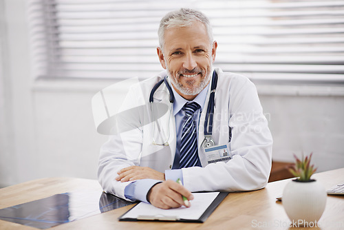 Image of Healthcare, portrait and male doctor with a clipboard in his office analyzing xray document in hospital. Confidence, smile and professional mature man medical worker with paperwork by desk in clinic.