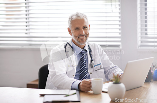 Image of Happy, laptop and portrait of a male doctor in his office doing diagnosis research in a hospital. Confidence, success and professional mature man healthcare worker with a computer in medical clinic.