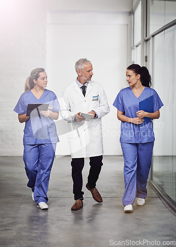 Image of Medical team, healthcare and doctors talking in a hospital with a clipboard and tablet for health insurance. Senior chief and nurses or a man and women together for a discussion, results and planning