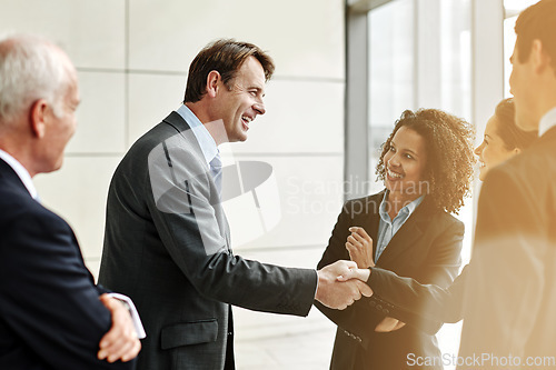 Image of Group, professional and negotiation with handshake for agreement with conversation at the office. Business, people and welcome partner in the lobby for a discussion about contract in the company.