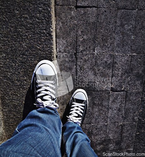 Image of Pov, shoes and man in a road for travel, weekend and fun in a city alone. Above, feet and male in a street with sneakers outdoors for walking, commute or solo travelling while exploring town on foot