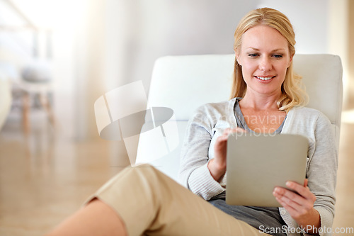 Image of Happy woman, tablet and smile in living room for social media, research or browsing on chair at home. Female person smiling and relaxing on technology for communication or online search at the house