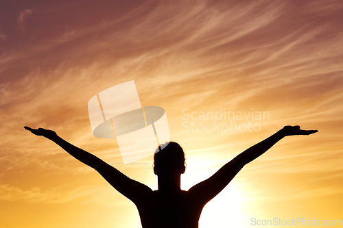 Image of Silhouette, sunset with person, open arms and freedom outdoor, orange sky with fresh air and celebrate life. Meditation, wellness and healing with peace, shadow and horizon with worship or spiritual